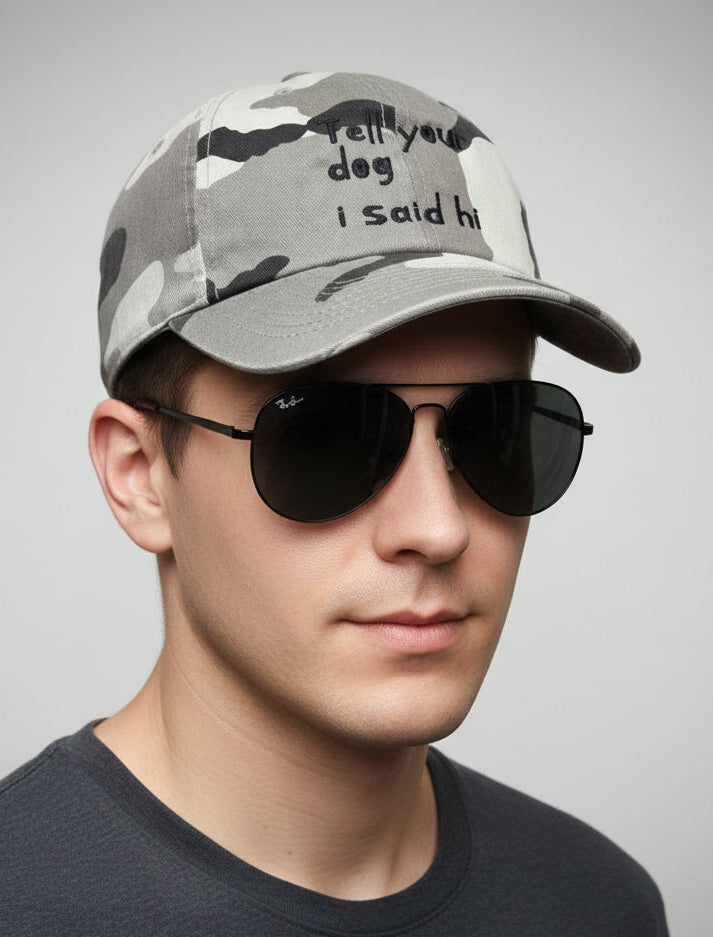 camouflage hat with tell your dog i said hi embroidered on it